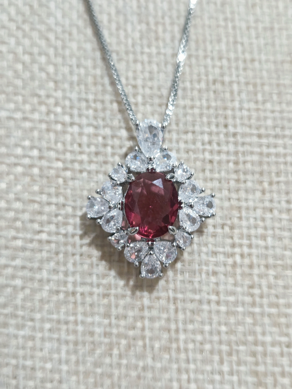 Silver Necklace with Ruby Oval Centerstone and Clear Halo